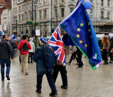 People at a Brexit demonstration. A protester carries a European Union flag and a British flag