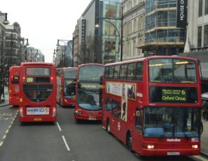 View of Oxford street in London with five red double-decker buses
