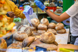 Market stall selling bread. The stallholder is giving change to a person who has just bought something