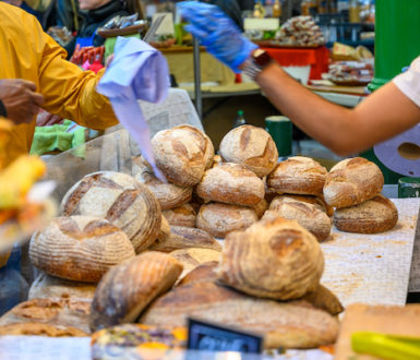 Market stall selling bread. The stallholder is giving change to a person who has just bought something