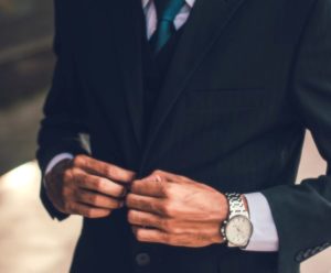 Man buttoning a dark suit