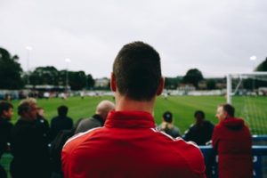 Group of men watching sport, seen from behind