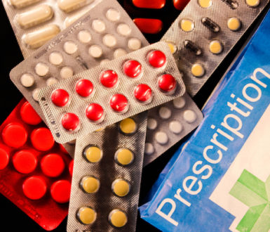 Packets of pills and a paper prescription medicine bag