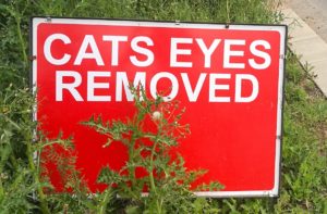 Red sign with the words Cats Eyes Removed