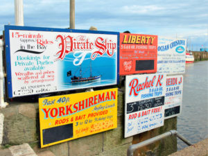 Variety of signs for pleasure boat trips called Pirate and Yorkshireman