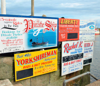 Variety of signs for pleasure boat trips called Pirate and Yorkshireman