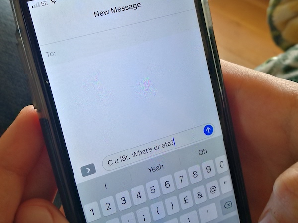 Text message language. Close up of mobile phone with the words C U L 8 R typed on the screen