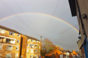 Street with houses and flats, and a rainbow over the top